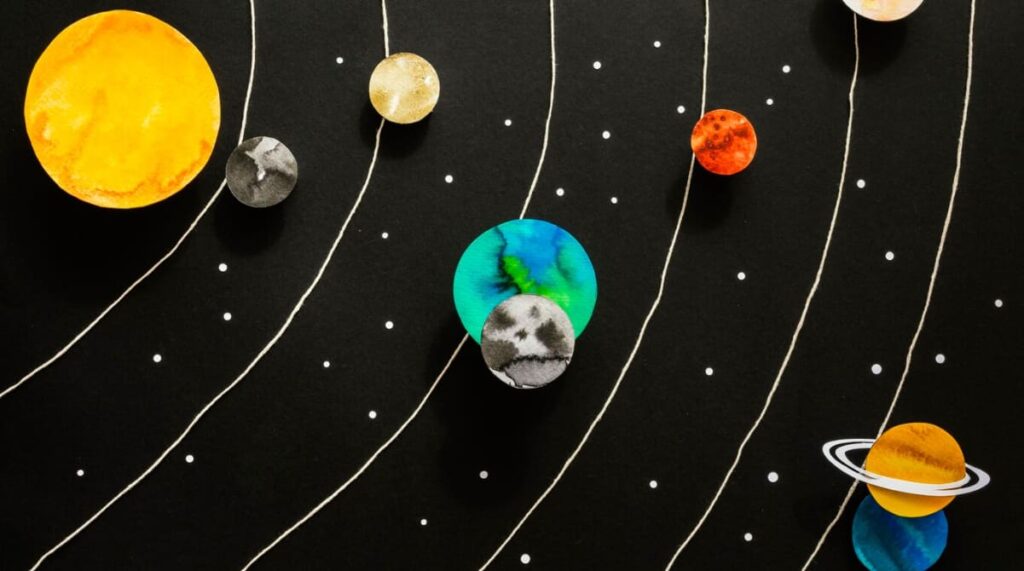 A creative representation of the solar system with painted planets on a dark background