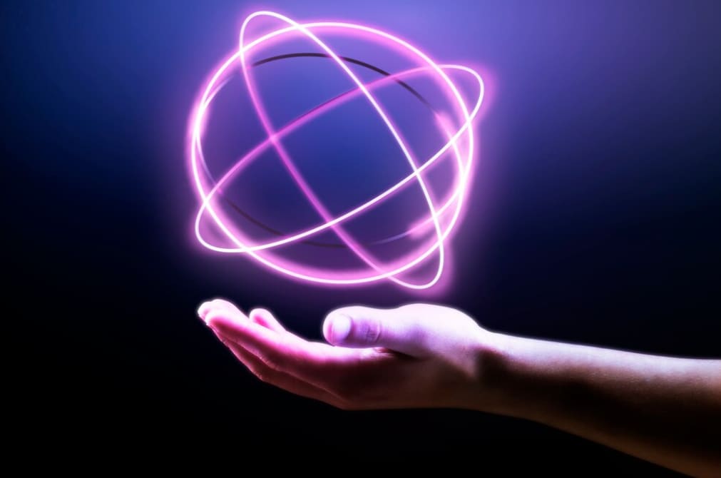A hand with a neon purple orbiting electron illustration hovering above it